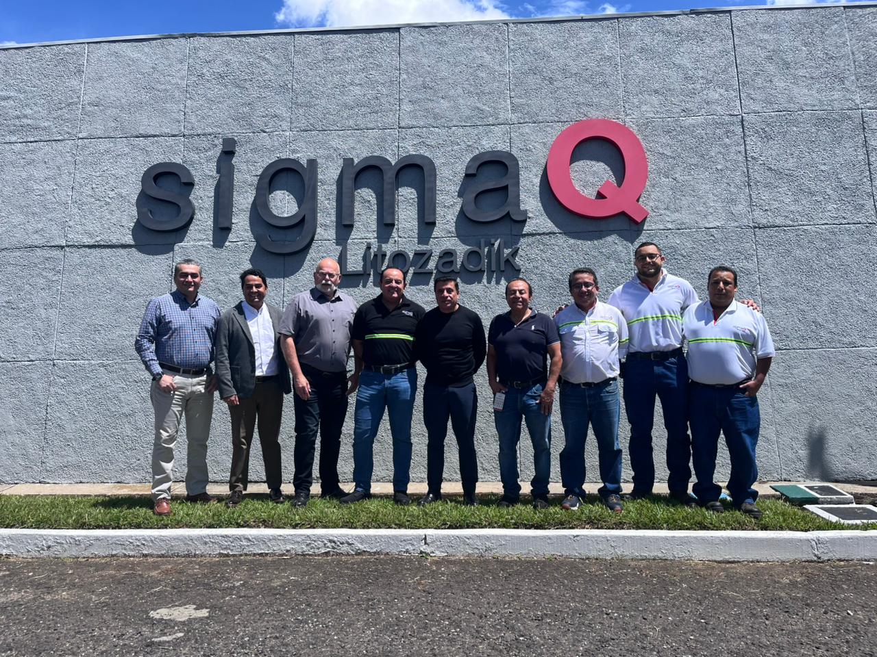 MM Board & Paper team and SigmaQ standing next to the company sign at their HQ in Guatemala for a visit on folding carton packaging performance.